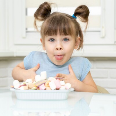 zadowolona dziewczynka z talerzem słodyczy